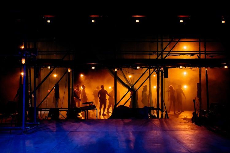 Actors silhouetted in the background of the set of Provok'd